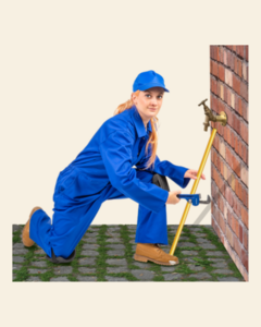 A woman dressed as a plumber is mending pipes on an outside wall